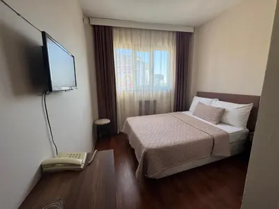 a hotel room with a bed and a flat screen tv at Otel Parpali in Istanbul