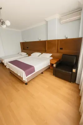 a bedroom with a bed and a chair at Ferah Otel in Gebze