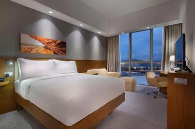 a hotel room with a large bed and a desk at Hampton By Hilton Kocaeli Symbol in Kocaeli