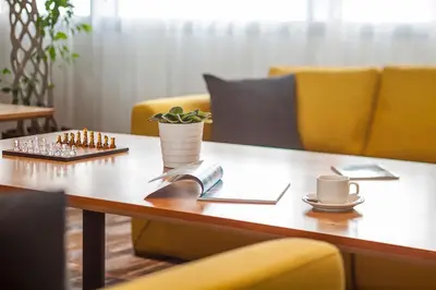 a wooden table with a cup of coffee and a plant on it at Hampton By Hilton Kocaeli Symbol in Kocaeli
