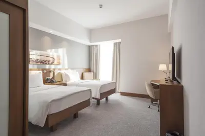 a hotel room with two beds and a desk at Hampton By Hilton Kocaeli Symbol in Kocaeli