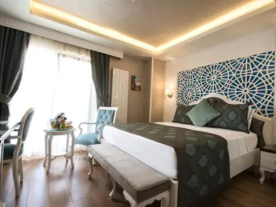 a hotel room with a large bed and a table at Antusa Palace Hotel & Spa in Istanbul