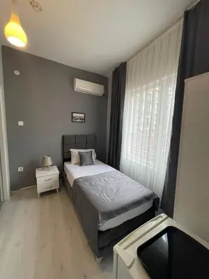 a bedroom with a bed and a window and a sink at Oldmile Palace Hotel in Istanbul