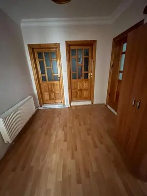 an empty room with wooden doors and wooden floors at bahçeli ve göl manzaralı ev in Sapanca