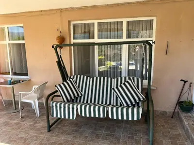 a couch sitting on a porch with a window at bahçeli ve göl manzaralı ev in Sapanca