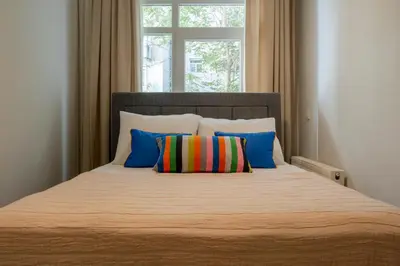 a bed with colorful pillows and a window at 3 Bedrooms and Central Location in Istanbul
