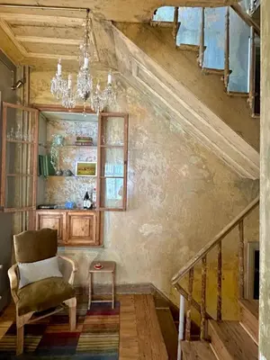 a staircase with a chair and a chandelier at Balat Istanbul Three-Story Restored Ottoman House in Istanbul
