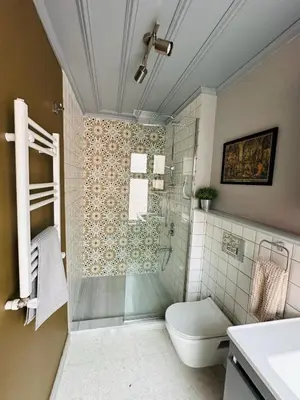 a bathroom with a toilet and a glass shower at Balat Istanbul Three-Story Restored Ottoman House in Istanbul