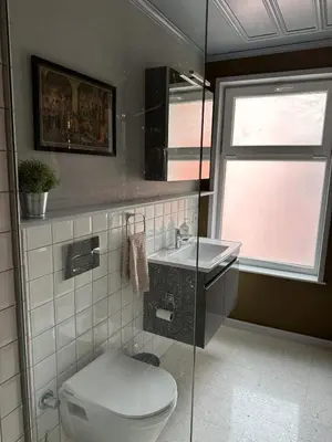 a bathroom with a toilet and a sink and a window at Balat Istanbul Three-Story Restored Ottoman House in Istanbul