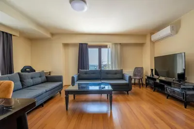 a living room with a couch and a flat screen tv at Spacious One Bedroom Apartment with View and Elevator in Istanbul