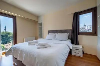 a bedroom with a large bed with white sheets and a window at Spacious One Bedroom Apartment with View and Elevator in Istanbul