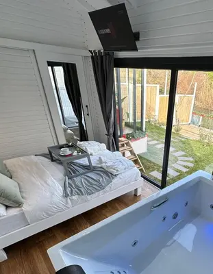 a bedroom with a bed and a bath tub at Ağva Nehir Kenarı TinyHouse Jakuzili in Sile