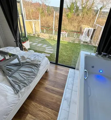 a bedroom with a bed and a tub and a window at Ağva Nehir Kenarı TinyHouse Jakuzili in Sile