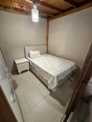 a small bedroom with a bed and a night stand at Görkem Suits & Villas in Ocaklar