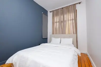 a bedroom with a white bed with a blue wall at Private Building Featuring Two Separate Apartments in Istanbul