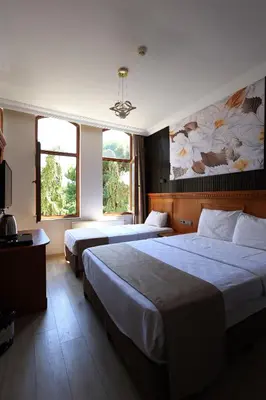 a hotel room with two beds and two windows at New House Hotel in Istanbul