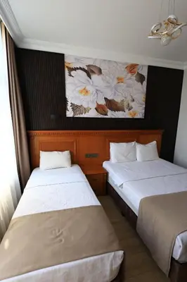 two beds in a hotel room with a painting on the wall at New House Hotel in Istanbul