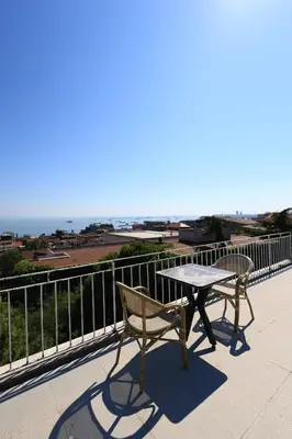 a table and chair on a balcony with a view of the ocean at New House Hotel in Istanbul