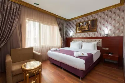 a hotel room with a bed and a chair at Alrazi Hotel in Istanbul