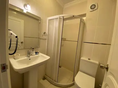 a bathroom with a shower and a sink at Sato Hotel in Marmara
