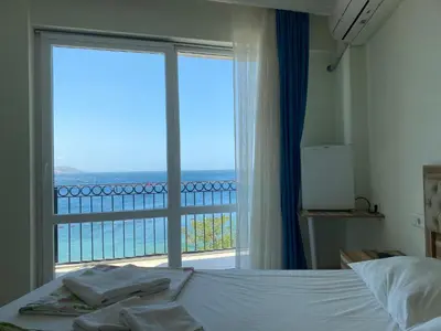 a bedroom with a bed and a large window at Sato Hotel in Marmara