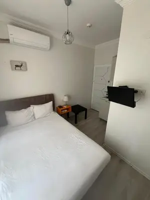 a bedroom with a white bed and a table at Şişli Suites - Room33 in Istanbul