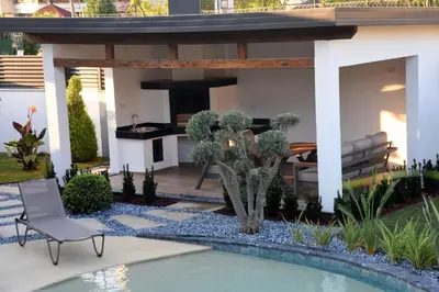 a garden with a pool and a house with a patio at maura beach villas family in Kartepe