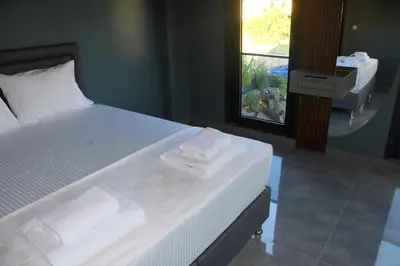 a large bed with two towels on it in a room at maura beach villas family in Kartepe