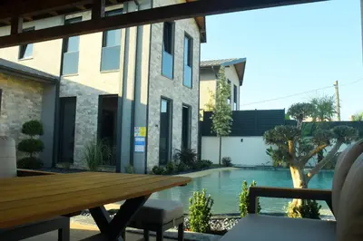 a patio with a wooden table and a swimming pool at maura beach villas family in Kartepe