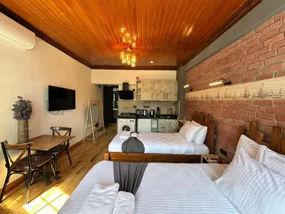 a room with two beds and a table and a kitchen at MorAgop Suites in Istanbul