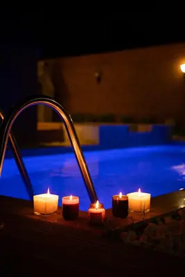 a sink with lit candles next to a swimming pool at Armoni Life Bungalov in Yanık