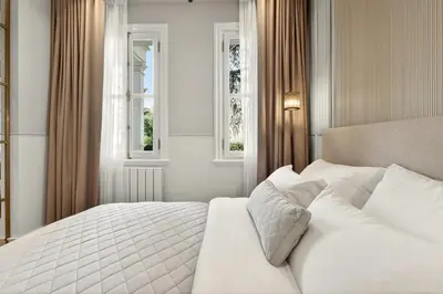 a bedroom with a white bed with two windows at Arbor Hotel - Signature Collection in Istanbul