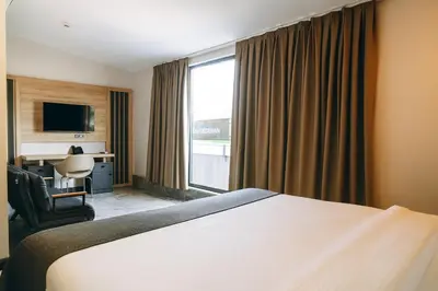 a hotel room with a bed and a desk and a window at Rest By Dedeman Sapanca in Sapanca