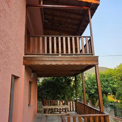 a balcony on the side of a house with a bench at Uludağ Tatil Evleri & Villa Şirin in Soğukpınar