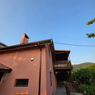 a red brick building with a balcony on the side at Uludağ Tatil Evleri & Villa Şirin in Soğukpınar