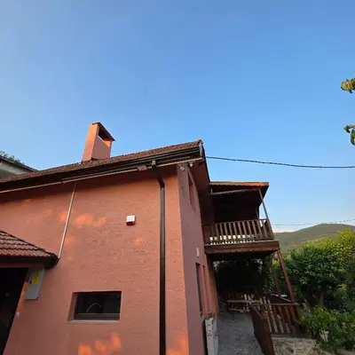 a red brick building with a balcony on it at Uludağ Tatil Evleri & Villa Şirin in Soğukpınar