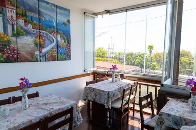 a dining room with two tables and a painting on the wall at Galley Hotel in Istanbul