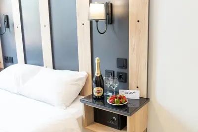 a bottle of champagne and a bowl of fruit on a bed at Galley Hotel in Istanbul