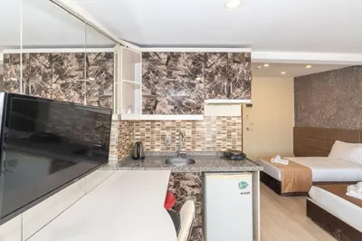a kitchen with a sink and a living room with a bed at Terra Suites in Istanbul