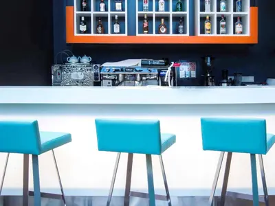 two blue chairs sitting in front of a bar at The Elysium Styles Taksim in Istanbul