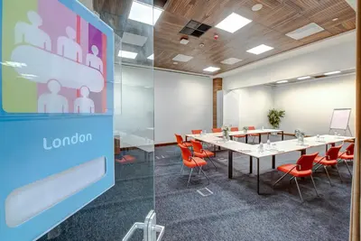 a conference room with a long table and orange chairs at The Elysium Styles Taksim in Istanbul