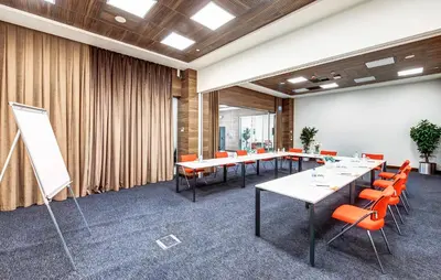 a conference room with long tables and orange chairs at The Elysium Styles Taksim in Istanbul
