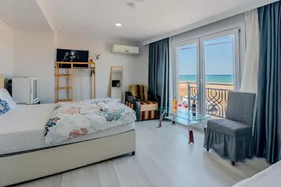 a bedroom with a bed and a balcony with the ocean at İstanbul Airport Holiday Beach Hotel in Arnavutköy