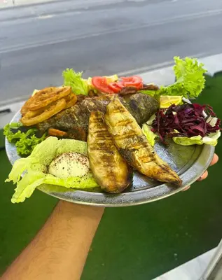 a person holding a plate with a plate of food at İstanbul Airport Holiday Beach Hotel in Arnavutköy
