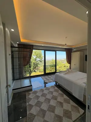 a bedroom with a large bed and a large window at Villa in nature in Sapanca