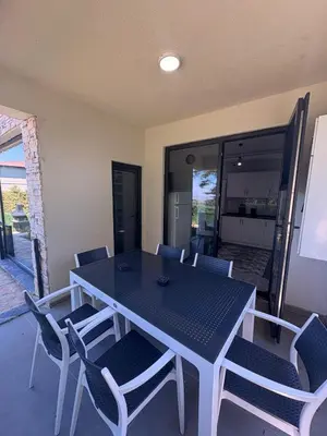 a dining table and chairs with a kitchen in the background at Villa in nature in Sapanca