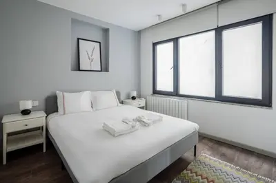 a bedroom with a large white bed with two windows at Amazing Luxury Duplex High Ceiling Patio! #403 in Istanbul