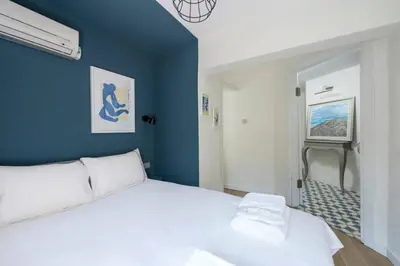 a bedroom with a white bed and a blue wall at Beautiful Modern Bright 2BD Patio Duplex #179 in Istanbul