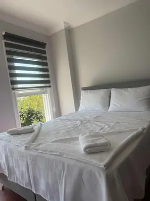 a white bed with two towels on it with a window at Mehmet Paşa Konağı in Istanbul
