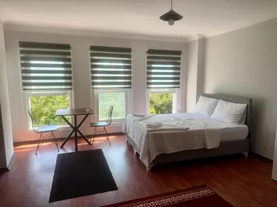a bedroom with a bed and two windows with blinds at Mehmet Paşa Konağı in Istanbul